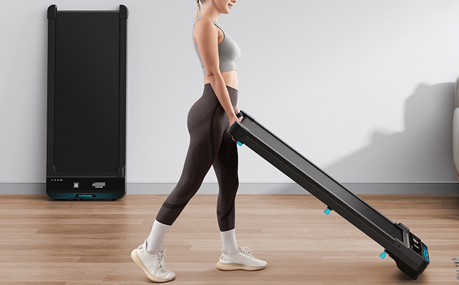 A Person Lifting an Under Desk Treadmill