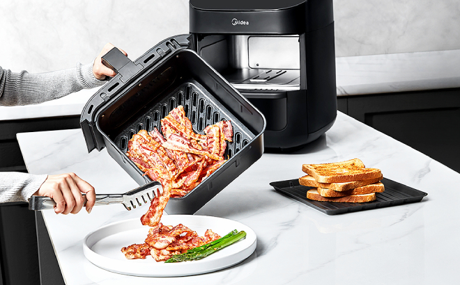 A Person Putting Bacons Cooked in Midea Air Fryer Oven in a Plate