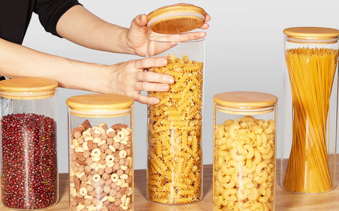 A Person Using Glass Food Storage Jars for Kitchen Organization