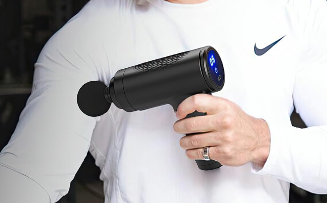 A Person Using a Mini Massage Gun on His Biceps