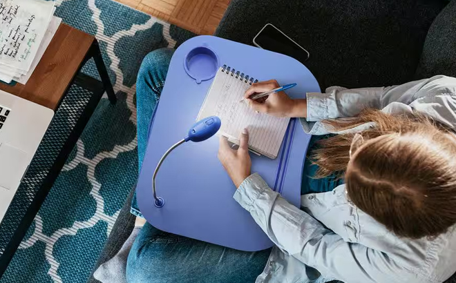 A Person Using the Foam Cushion Laptop Lap Desk with LED Gooseneck Light in Blue