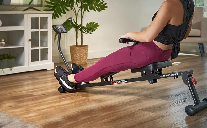 A Person Using the Sunny Health Fitness Compact Adjustable Rowing Machine