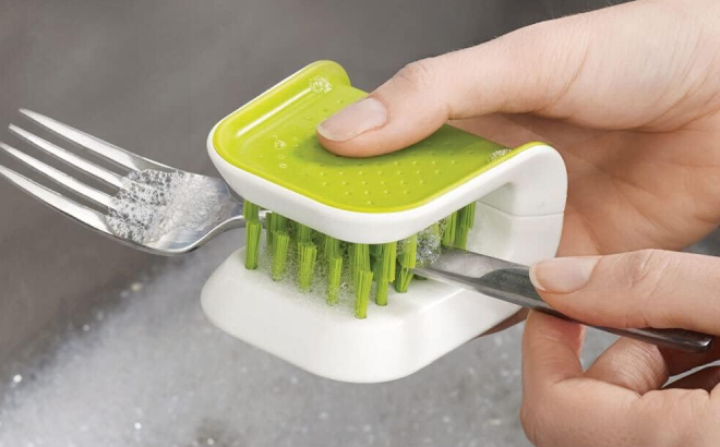 A Person Washing a Fork Using the Joseph Joseph Cleaner Brush