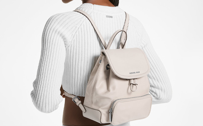 A Person Wearing Michael Kors Cara Small Nylon Backpack in Light Sand Color