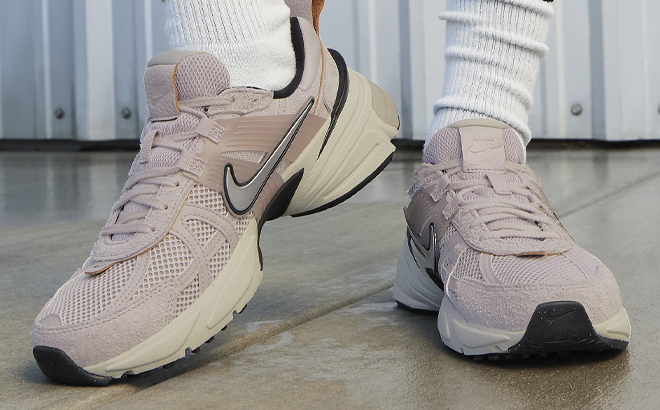 A Person Wearing Nike V2K Run Womens Shoes in Light Pink