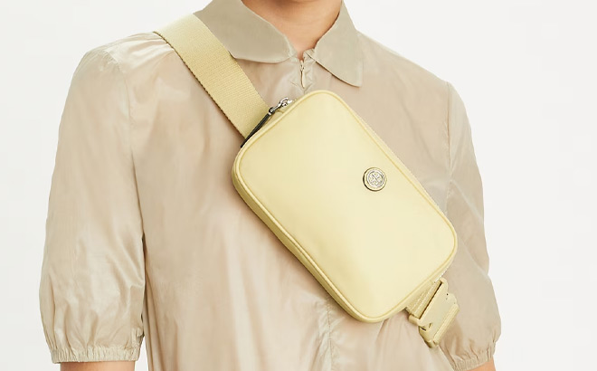 A Person Wearing Tory Burch Virginia Belt Bag in Lemon Sugar Color