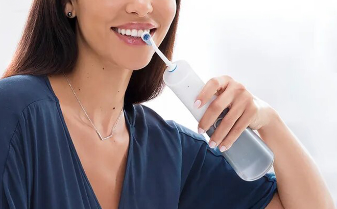 A Person flossing their Teeth with Oral B Water Flosser 