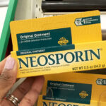 A Person holding Neosporin First Aid Antibiotic Ointment