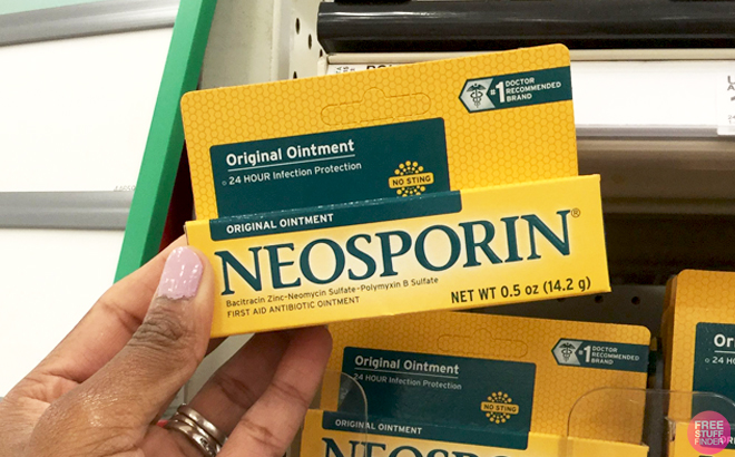 A Person holding Neosporin First Aid Antibiotic Ointment 