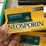 A Person holding Neosporin First Aid Antibiotic Ointment
