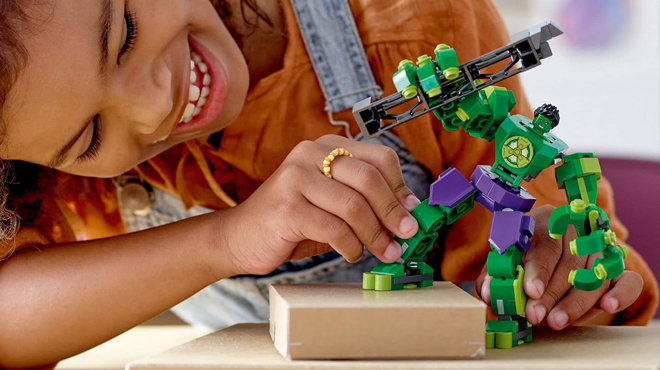 A Person playing with LEGO Marvel Hulk Action Figure