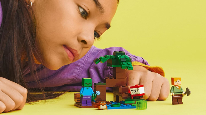 A Person playing with LEGO Minecraft The Swamp Adventure Building Set