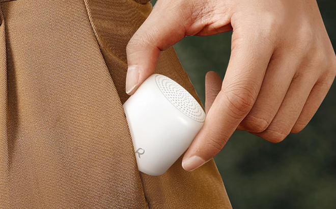 A Person putting a White Noise Sound Machine in their Pocket