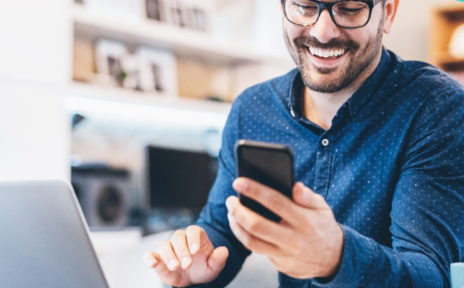 A Smiling Person Looking at Mobile Phone