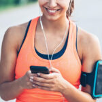 A Smiling Person in Activewear Looking at Mobile Phone