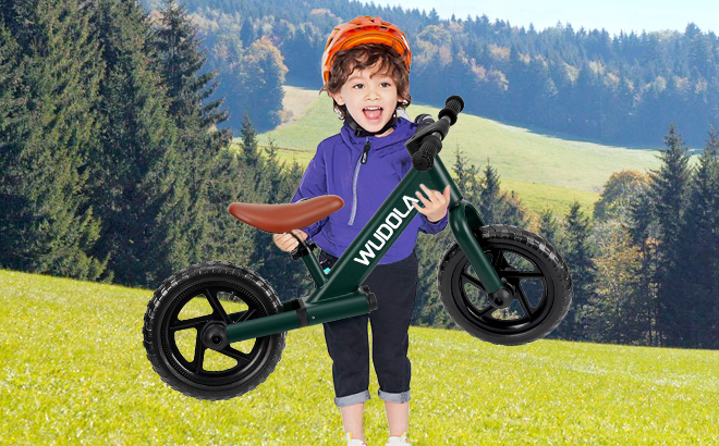 A Toddler Hodling a Balance Bike