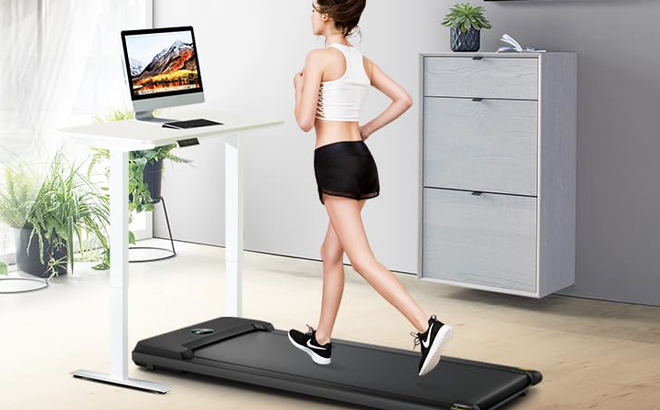 A Woman Running on an Under Desk Treadmill Walking Pad