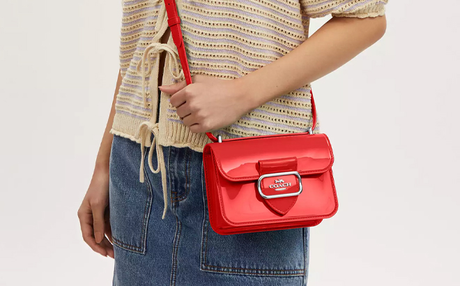 A Woman Wearing Coach Outlet Jelly Morgan Square Crossbody Bag in Miami Red