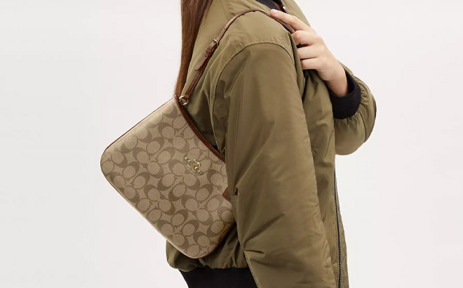 A Woman Wearing Coach Outlet Penelope Shoulder Bag In Signature Canvas