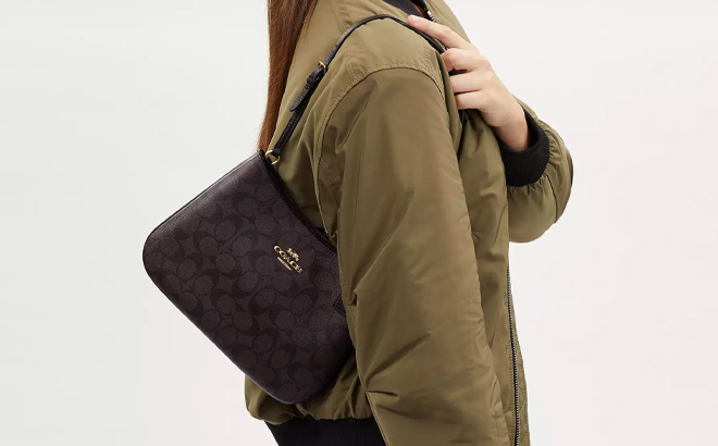 A Woman Wearing Coach Outlet Signature Canvas Penelope Shoulder Bag