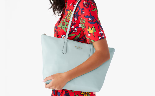 A Woman Wearing Kate Spade Kitt Nylon Large Tote in Blue Glow