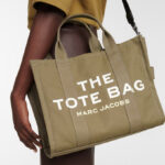 A Woman Wearing Marc Jacobs The Medium Tote Bag in Slate Green