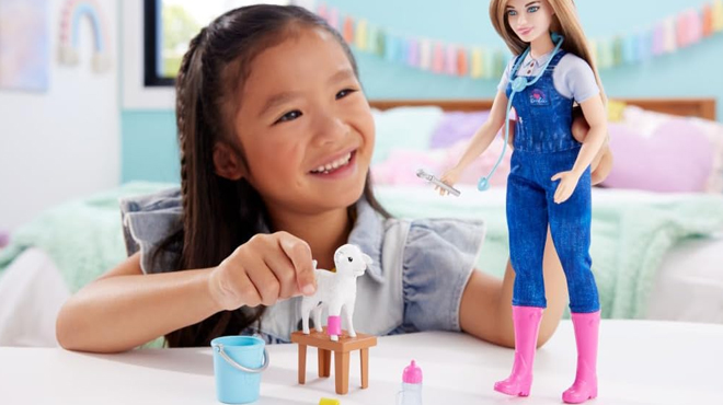 A girl playing with Barbie Veterinarian Set Fashion Doll