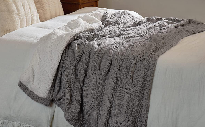 Amelie Home Reversible Sherpa Cable Knit Throw Blanket on a Bed