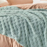 Bedsure Sage Green Fleece Blanket on a Bed