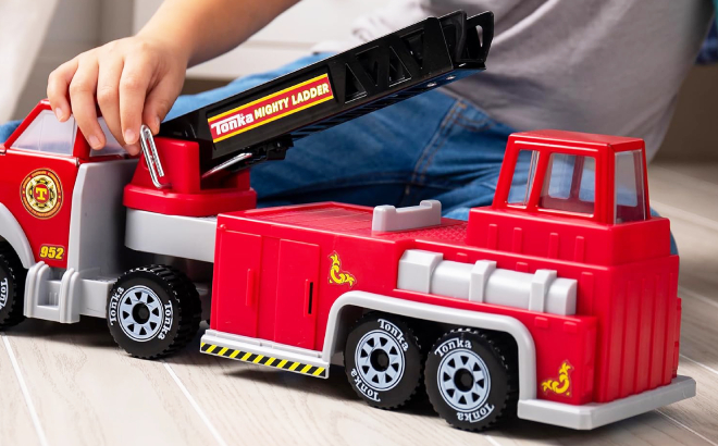 A Boy Playing with Tonka Steel Classics Hook N Ladder Fire Truck