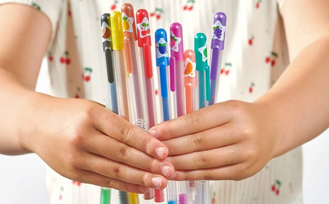 A Child Holding Ooly Scented Yummy Yummy Glitter Gel Pens