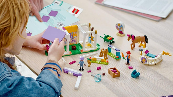 A Child Playing with LEGO Friends Horse Training Building Set