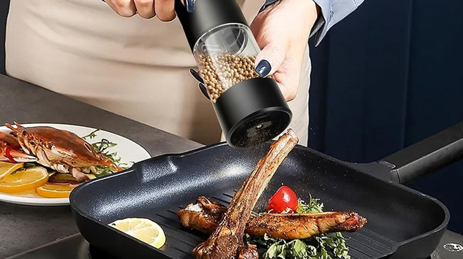 A Cook Grinding a Jeaduiwe Salt Pepper Grinder on a Meat