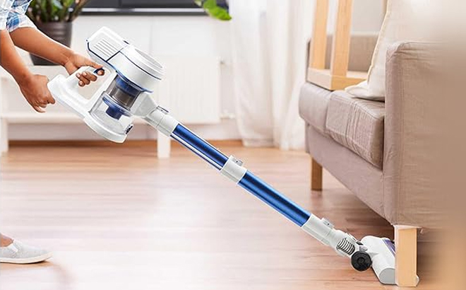 A Person Cleaning a Living Room using a Britech Cordless Stick Vacuum Cleaner