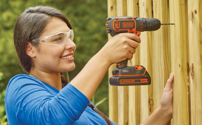 A Person Drilling a Hole on a Wood Using BlackDecker Max Cordless Drill