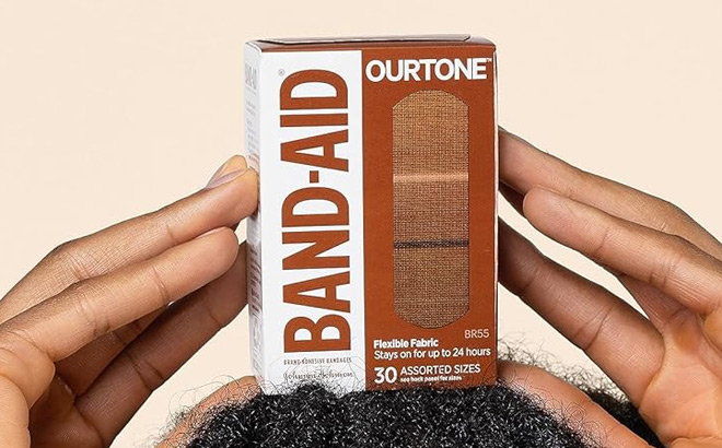 A Person Holding Band Aid Brand Ourtone Flexible Fabric Adhesive Bandages