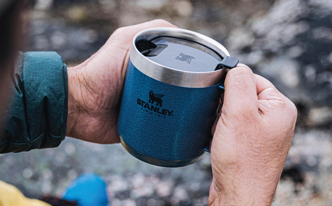 A Person Holding Stanley Classic Legendary Camp Mug in Hammertone Lake Color