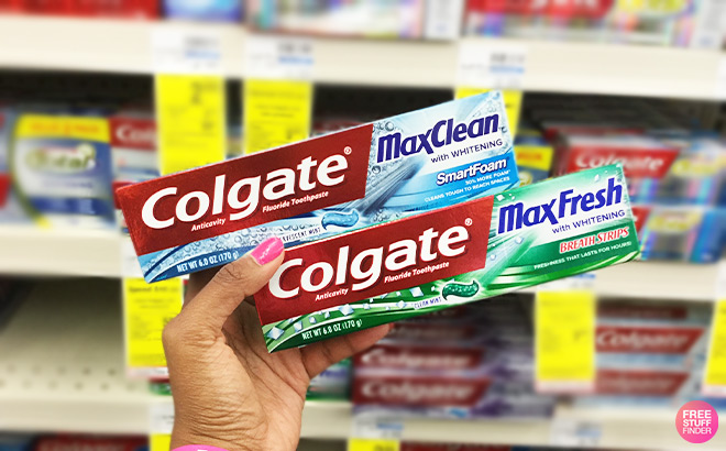 A Person Holding Two Colgate Toothpastes