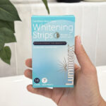 A Person Holding a Box of Lumineux Teeth Whitening Strips