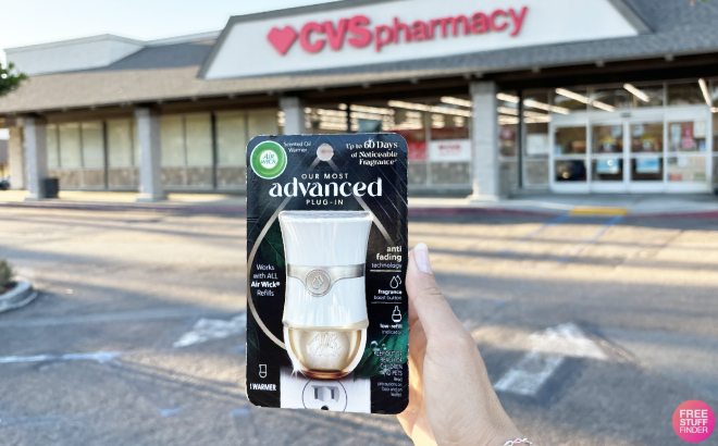 A Person Holding an Air Wick Advanced Scented Oil Air Plug In in front of CVS Store