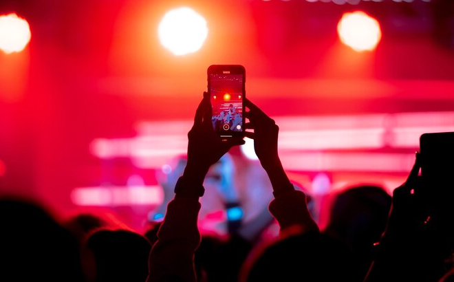 A Person Recording a Video Using iPhone in a Concert