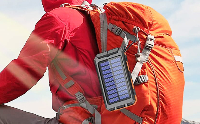 A Person Sitting with a Portable Solar Power Bank Attached to a Backpack