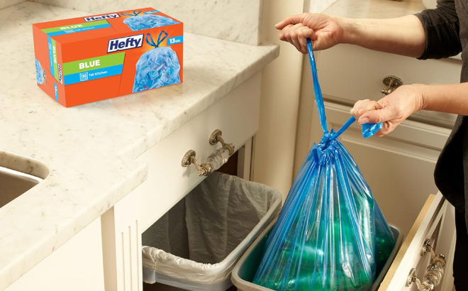 A Person Tying a Hefty Blue Trash Bag Filled with Bottles