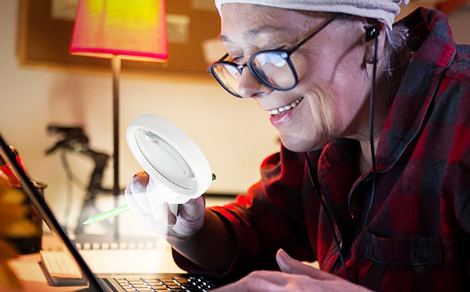 A Person Using a Magnifying Glass with Light in White Color