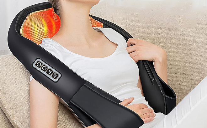 A Person Using the Shiatsu Back and Neck Heat Massager on a Couch