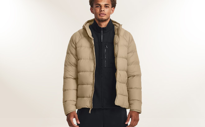 A Person Wearing Under Armour Storm Armour Down Mens Jacket in City Khaki Color