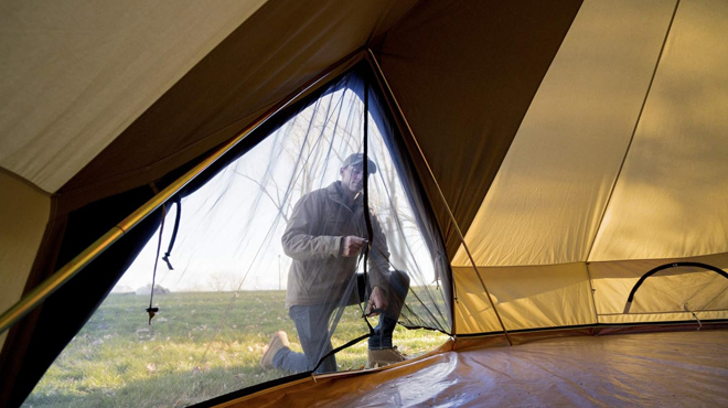 A Person Zipping up the Net door of Teton Sports Canvas Tent