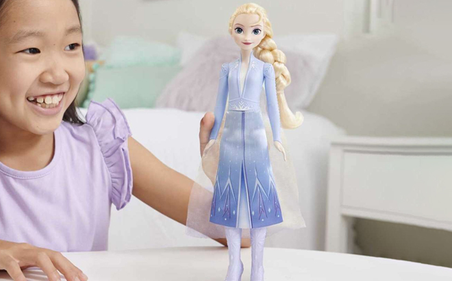 A Person holding a Disney Frozen Elsa Doll