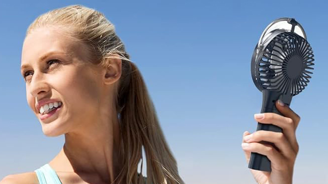 A Person holding a Handheld Misting Fan in Blue Color