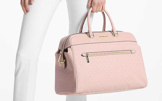 A Person holding a Michael Kors Weekender Bag